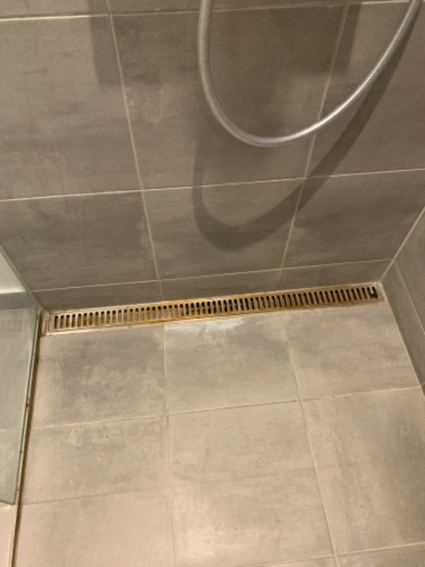 Grundigt rengøring af badeværelse. Resning af afløs, rengøring af rist i badet og afkalkning