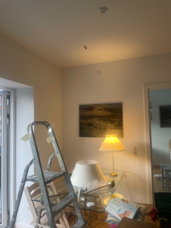 To loftslamper op og et stort spejl på væggen.