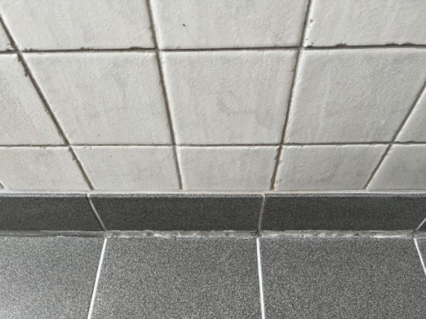 Omfugning af silikonefuge på mindre badeværelse.