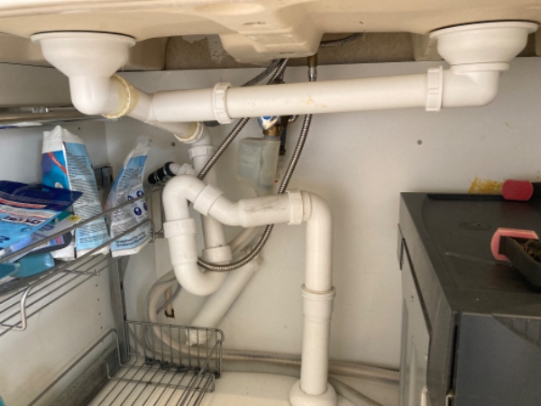 Montering af afløb/rør under køkkenvask