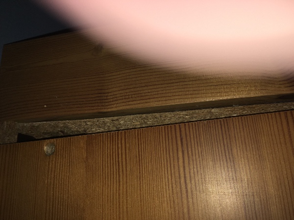 Et badeværelsesskab "hænger". Skal rettes op og fastgøres til en øvre ramme.