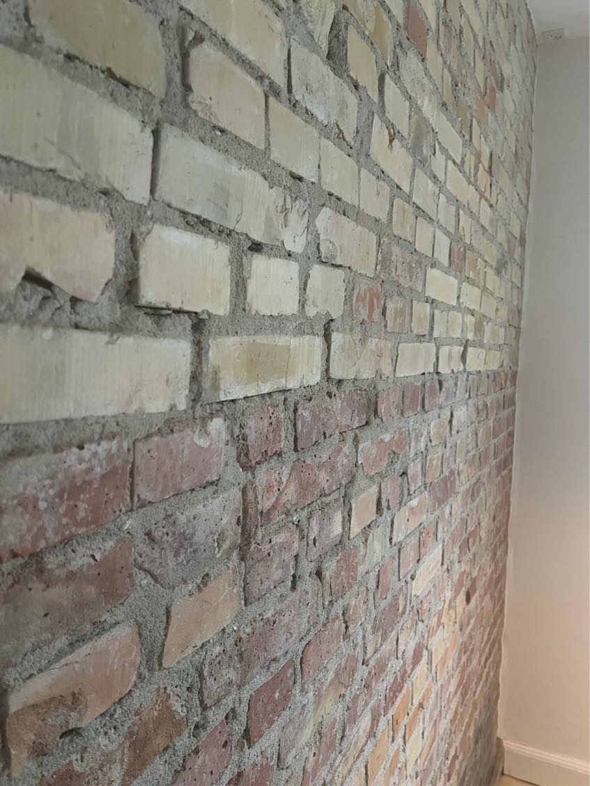 Pudsning og opsætning af filt af rå murstensvæg.