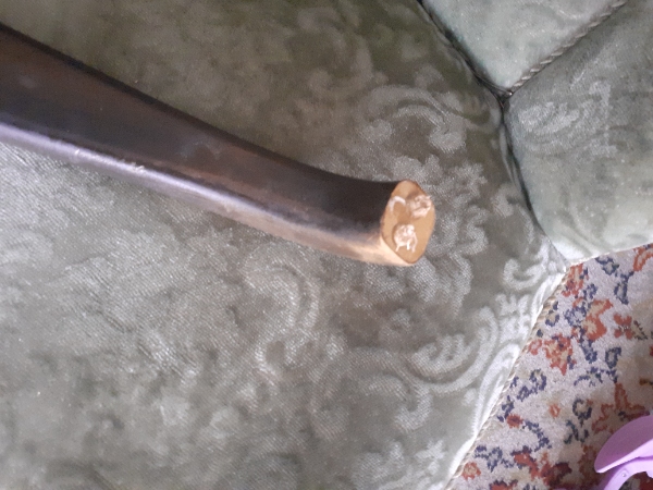 En gammel lænestol, hvor det ene armlæn er faldet af/ gået i stykker. Antik gammelt møbel-arvestykke