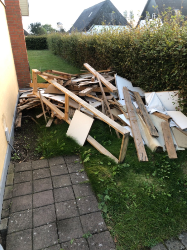 Bunker af affaldstræ og gulvtæpper og ander fra renovering af en 1.sal. Affaldet ligger i haven