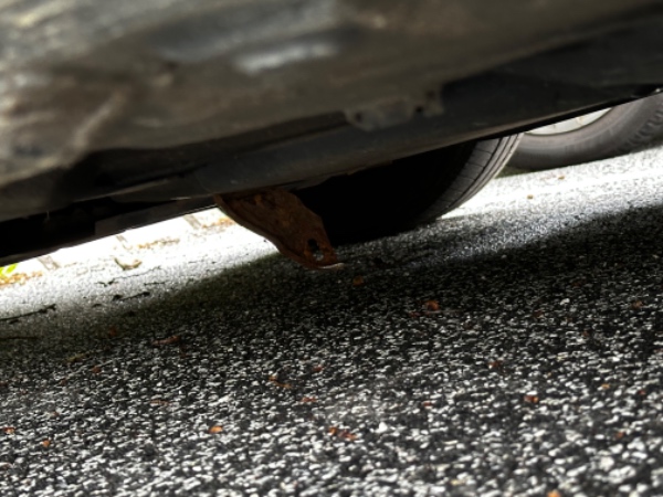 Metal hænger ned under bil