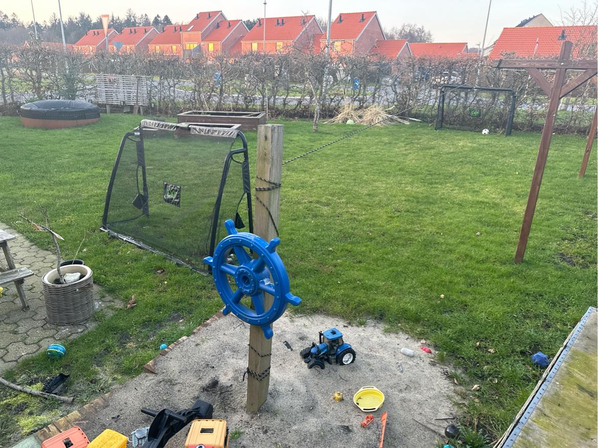 Robot plæneklipper kabel sættes rundt i haven.