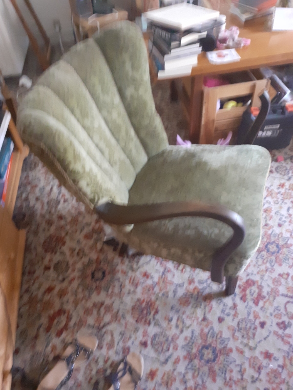 En gammel lænestol, hvor det ene armlæn er faldet af/ gået i stykker. Antik gammelt møbel-arvestykke