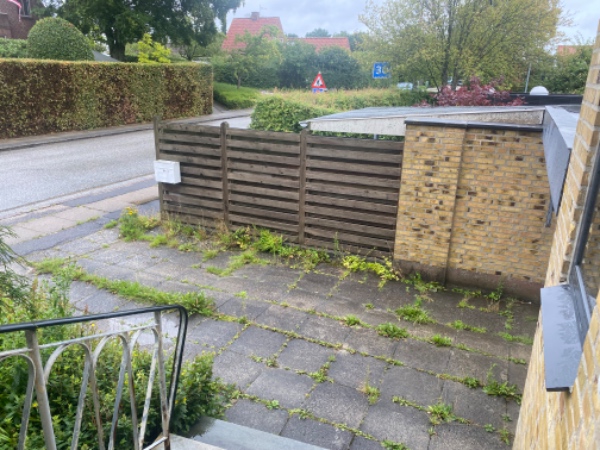 Fjernelse af ukrudt mellem fliser i to indkørsler.