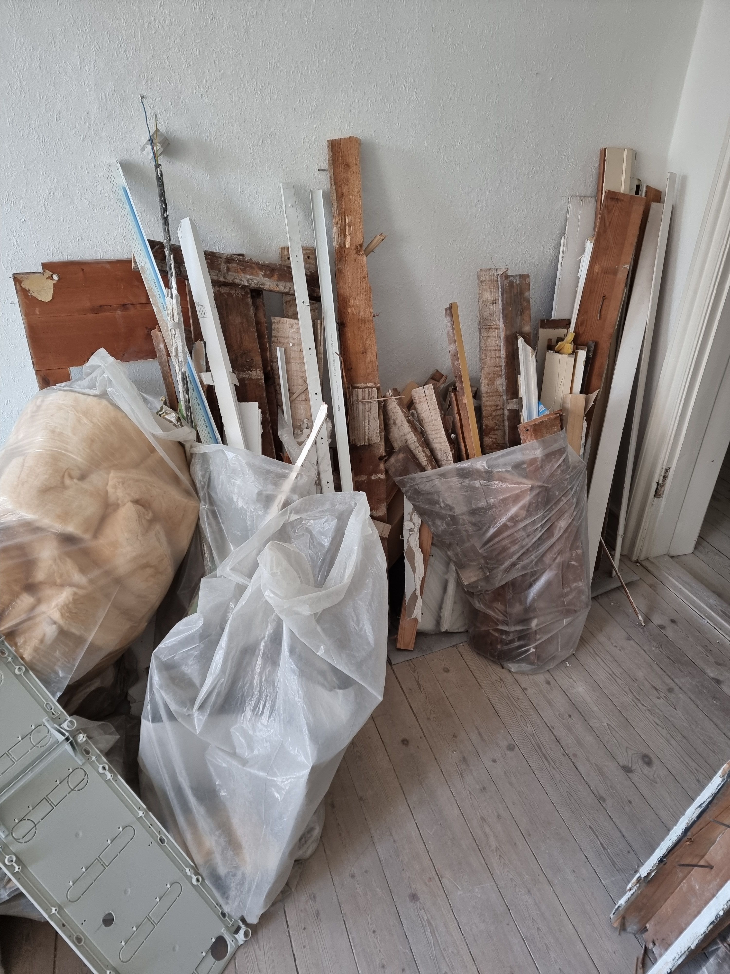 Fjernelse af byggeaffald efter nedrivning af væg i lejlighed