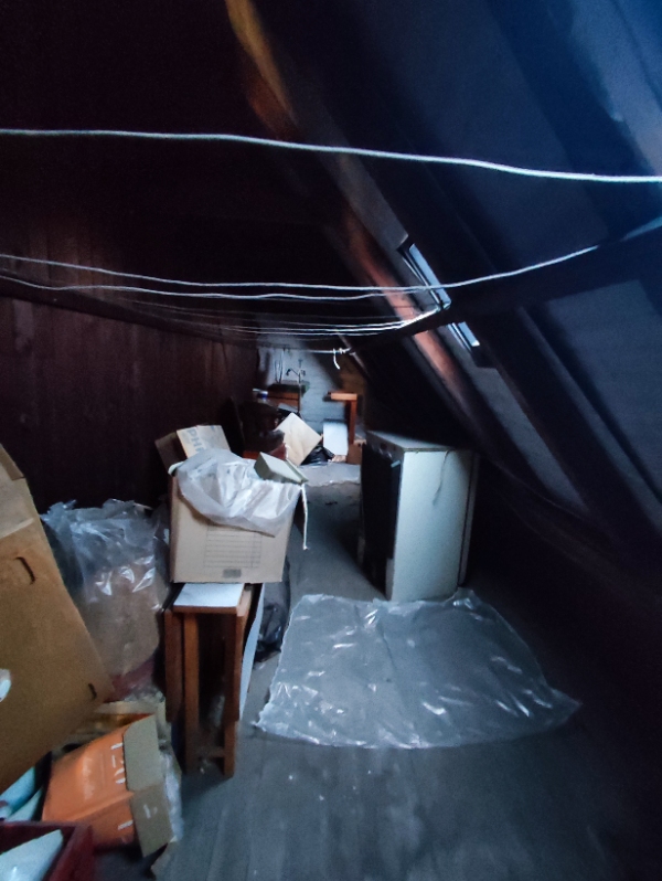 Et stort lofts med få mindre møbler og mange tomme kasser. Ingen elevator.