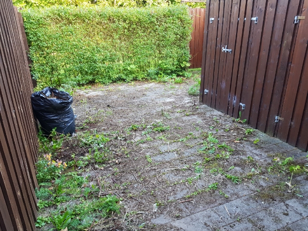 Luge ukrudt i lille baggård