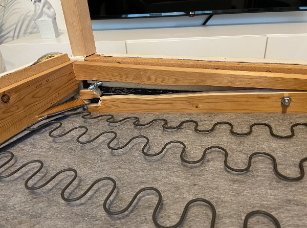 En sofa hvor træet i bunden har givet efter og er gået i stykker