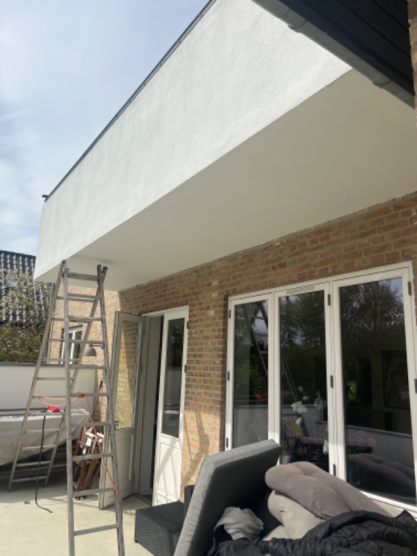 Opsætning af markise på underside af altan. Altan består af beton og metal gitter.