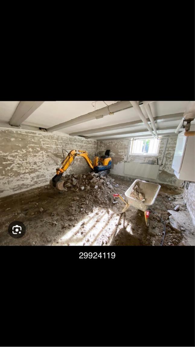 Kørsel med minigraver ved udgravning i kælder til isolering og støbning af gulv.