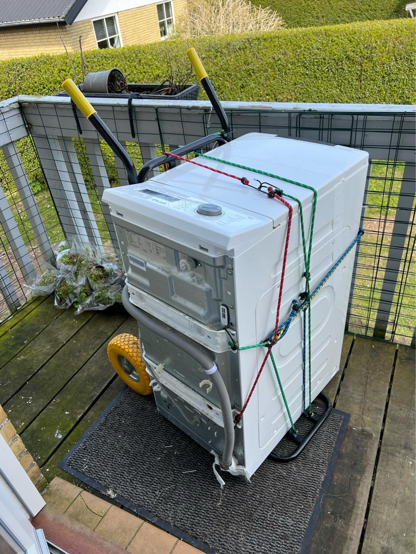 Vaskemaskine båret ned af trappe