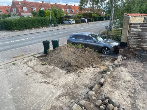 fjern ca. 6 kubikmeter jord og 10 sten, ø ~ 50 cm, lige ud til vej