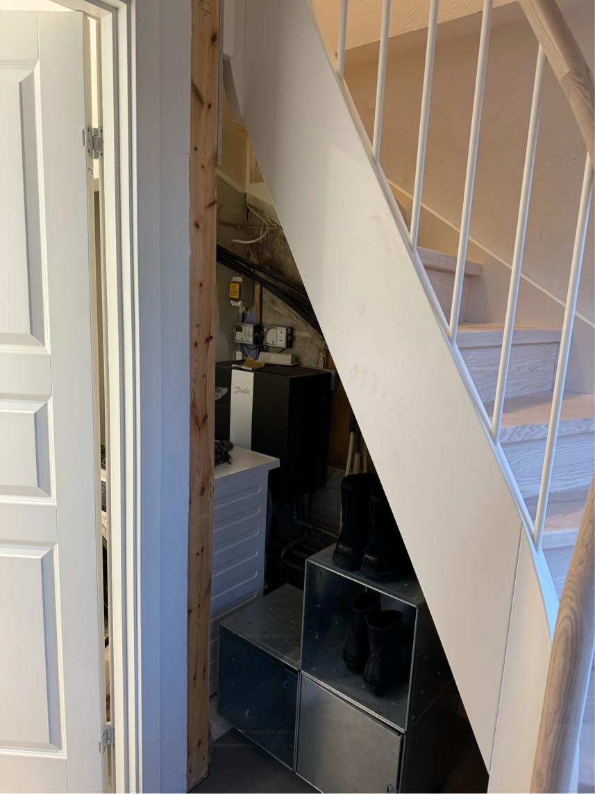 Væg under trappe, der lukker ind til badeværelse og skjuler installationer. Det er lidt svært at forklare.