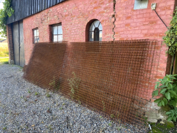 Rionet hegn hæftes og stolper graves ned til udvidelse af hønsegård.