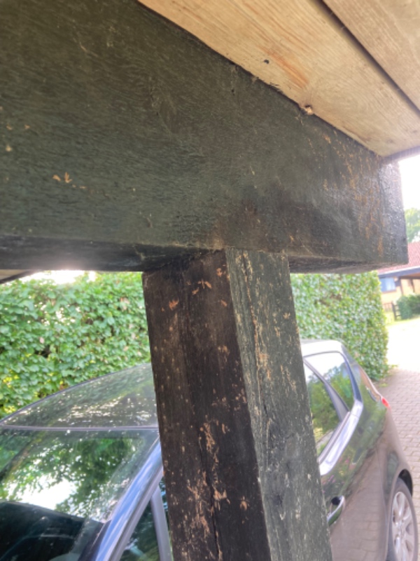 Skiftet 2 stolper i carporten. De står i et beslag ved jorden og skal ind under den tværgående bjælk