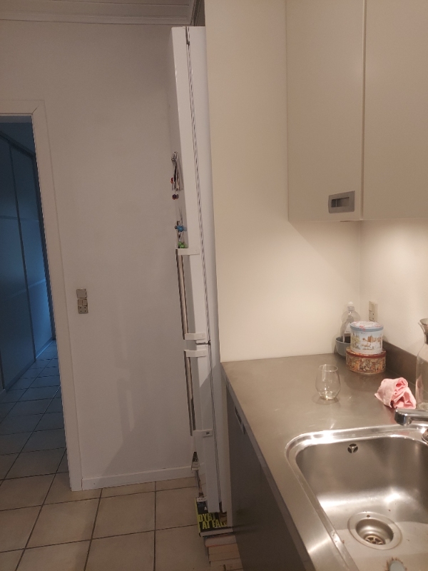 Flytte køle/fryseskab ud af skab. Fjerne bund i skab, så køle/fryseskab kan stå på gulvet.