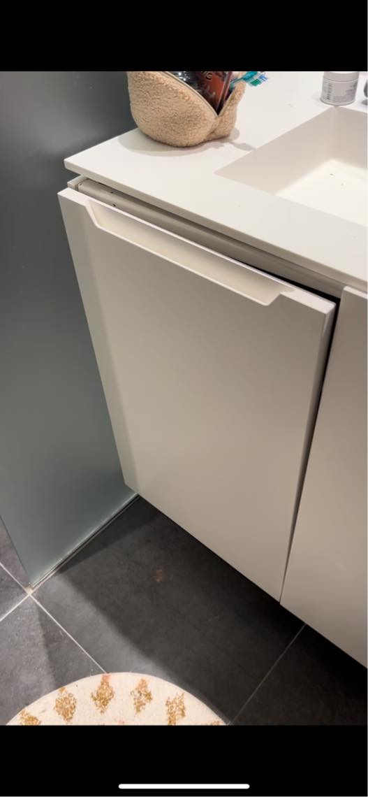 Badeværelsesskab hænger løst fra væg og bordplade