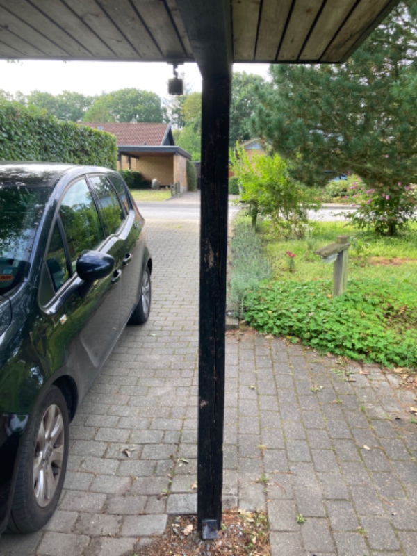 Skiftet 2 stolper i carporten. De står i et beslag ved jorden og skal ind under den tværgående bjælk
