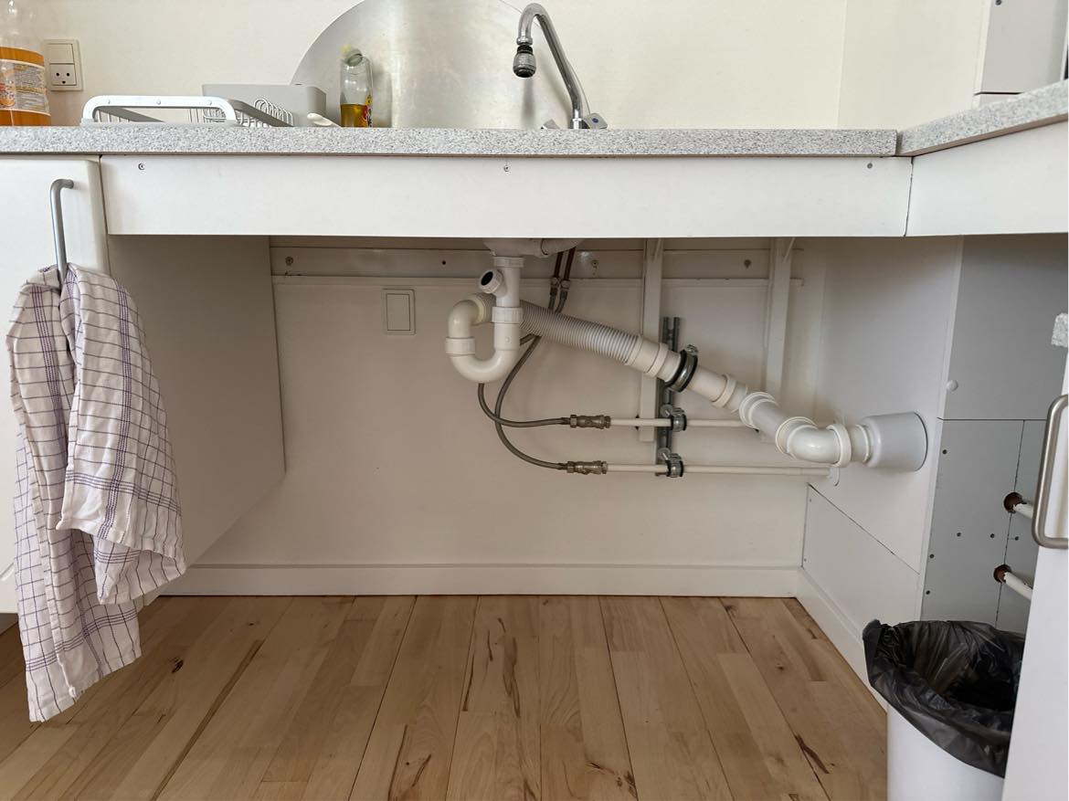 Hjælp til at skjule rør i køkkenet med en pæn hvid plade