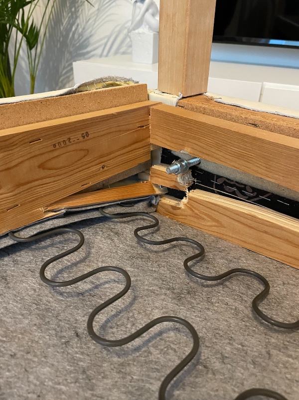 En sofa hvor træet i bunden har givet efter og er gået i stykker