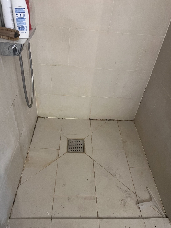 Omfugning af jordslåede fuger i brusekabine