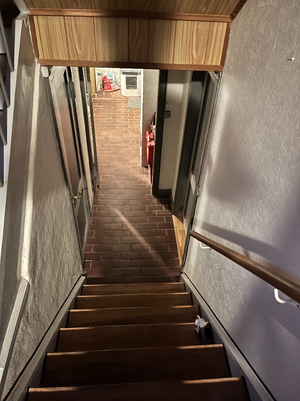 Fryser bæres ned i kælder med lavt loft