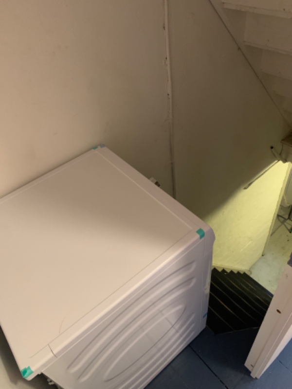 Flytte en tørretumbler ned ad en kældertrappe og løfte den gamle op og bortskaffe den