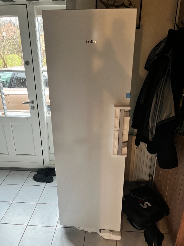 Fryser bæres ned i kælder med lavt loft