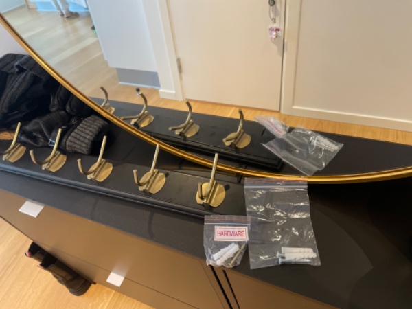 Ophæng af knagerække (L: 90 cm) og spejl (ø 80 cm) i entré med betonvæg