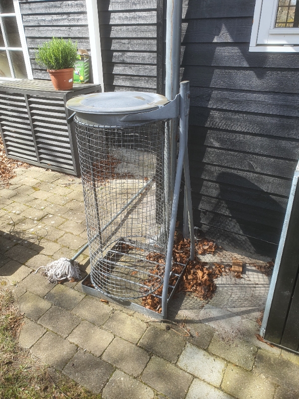 Gammelt metal skraldestativ, kørt på lossen, den type man havde for år tilbage