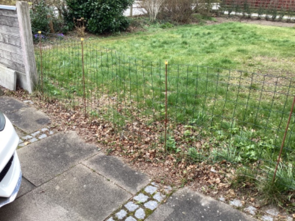 Genetableret et hegn. Betonstolpe sættes tilbage i hul, samt bundstykker og træ sættes på plads.