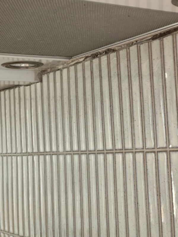 påfør silikone på toppen og bunden af flisevæggen i køkkenet