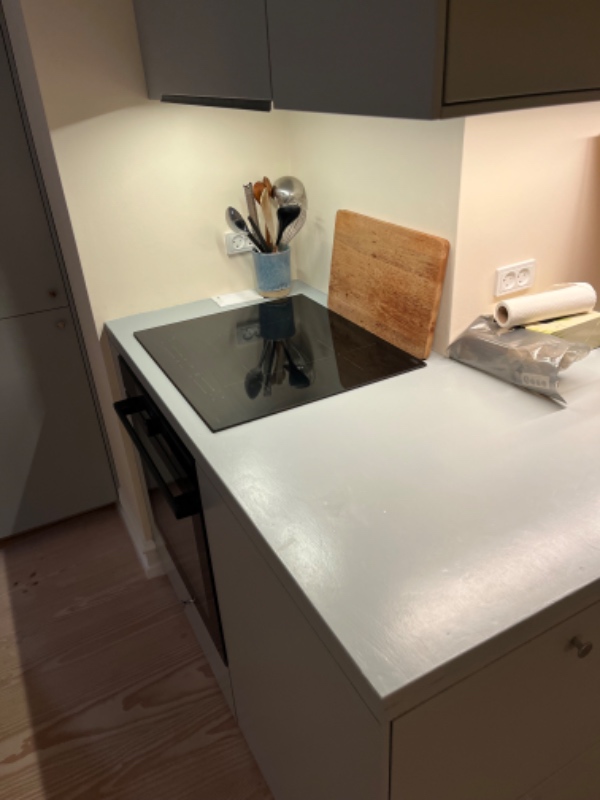 Afmontering af træbordplade og montering af lavastensbordplade i to dele samt fugning. Inderlommens af vask og påsætning og fugning af induktionsplade.