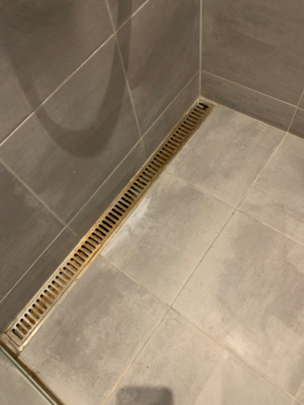 Grundigt rengøring af badeværelse. Resning af afløs, rengøring af rist i badet og afkalkning