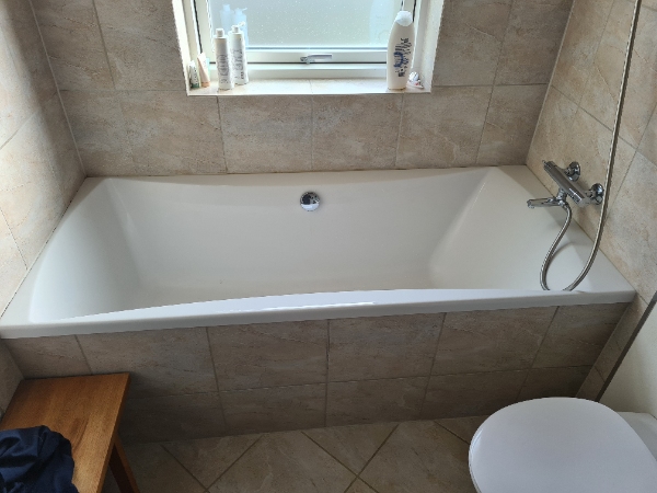 Udskiftet fugen i kanten af et badekar