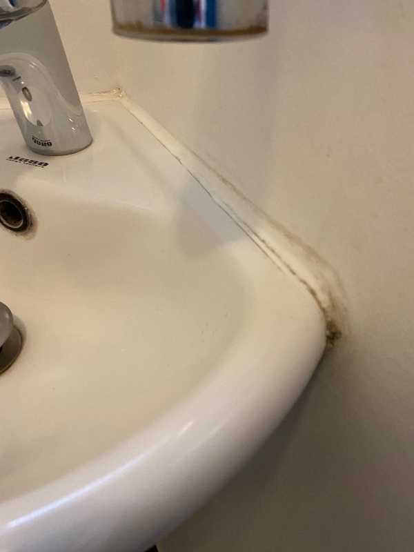 Fugning af løs flise på badeværelsegulv og skift af silikonefuge ved håndvask