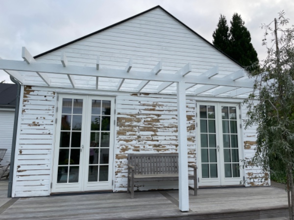 Der skal fjernes maling på en husgavl.