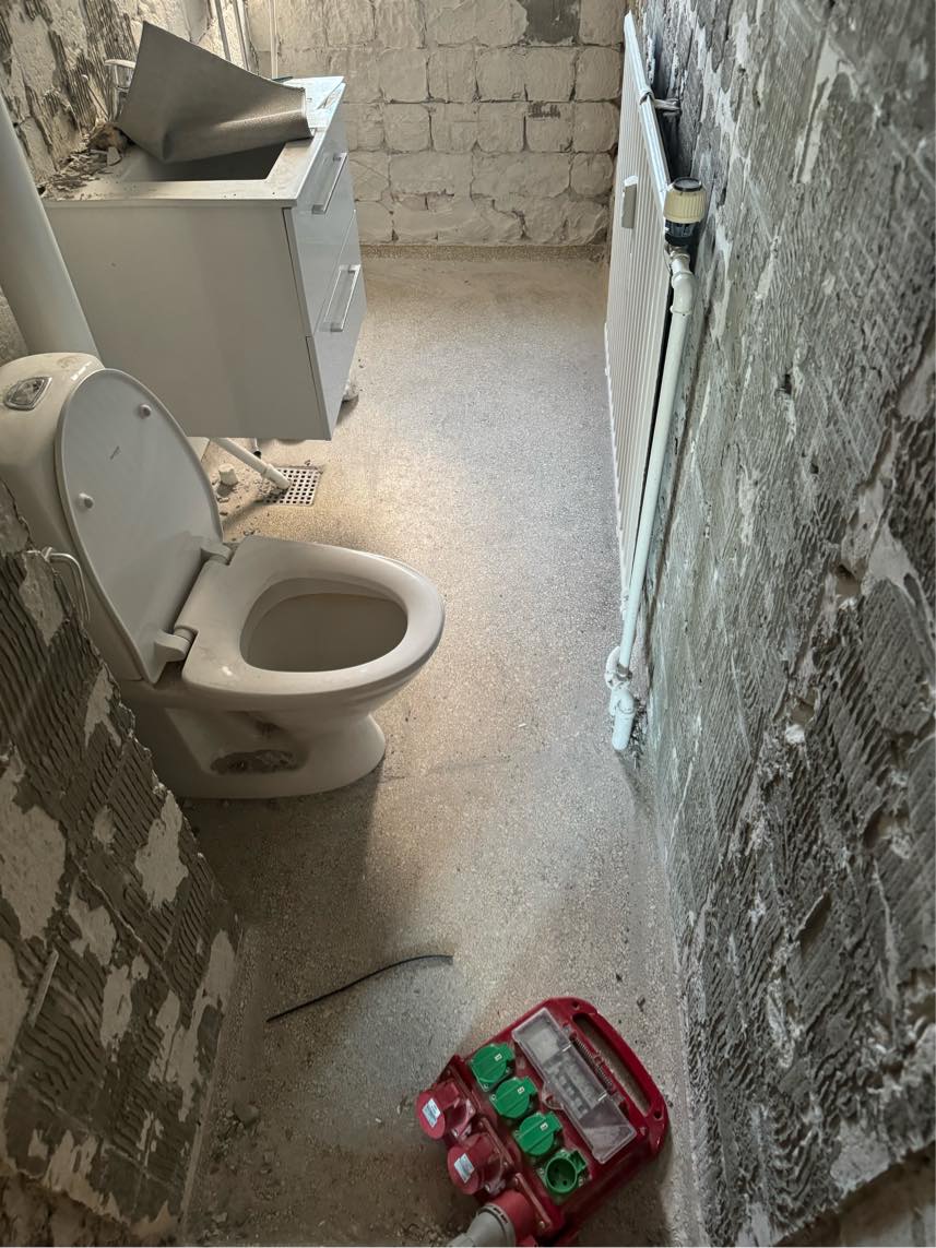 Banke terrazzo gulv op i badeværelse ned til beton