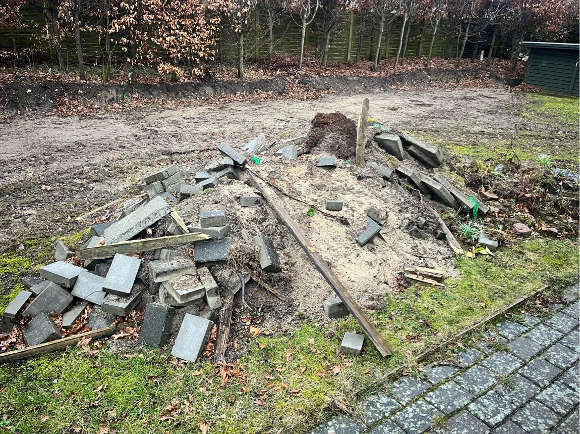 Fjernet jord og fliser fra haven  der kan komme en gravemaskine helt ind samt en trailer. Der er ca 5-6 ton