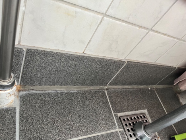 Omfugning af silikonefuge på mindre badeværelse.