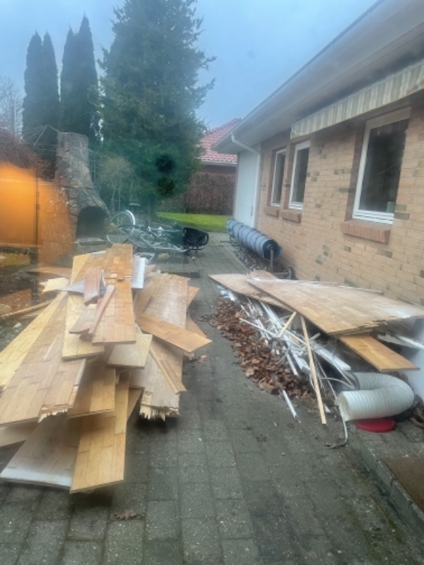 Byggeaffald: Gamle gulvbrædder, fliser og poser med afdækningsplast og -pap