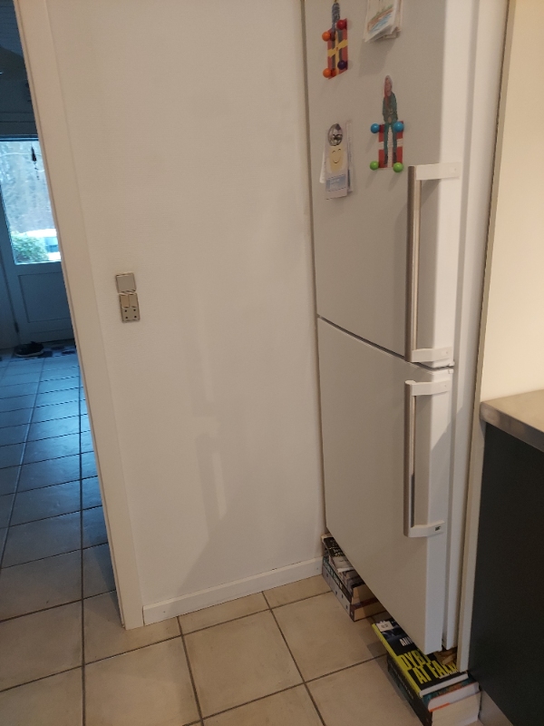 Flytte køle/fryseskab ud af skab. Fjerne bund i skab, så køle/fryseskab kan stå på gulvet.