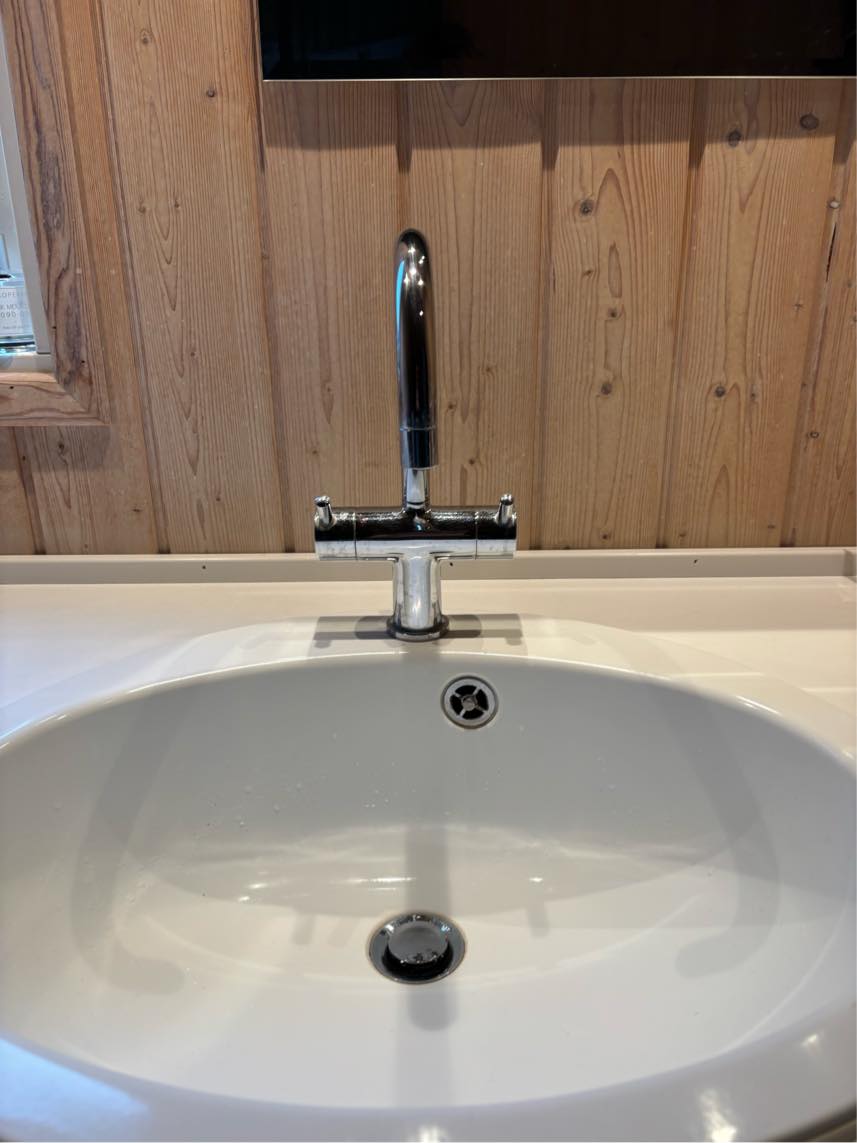 Udskiftning af blandingsbatteri på håndvask i badeværelse. Nyt batteri med sensor. Der er god plads under vask.