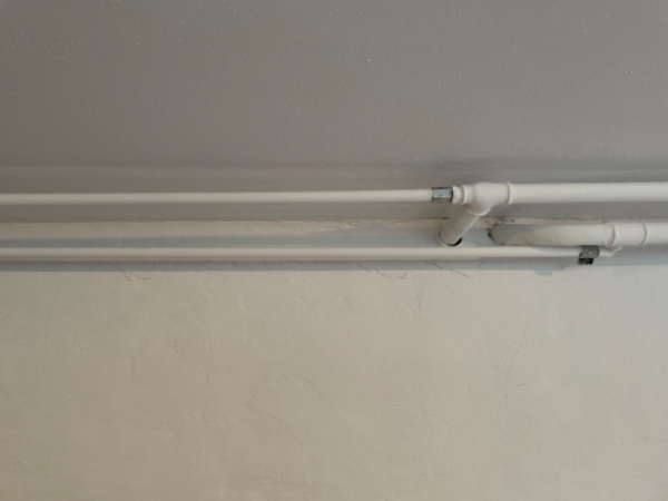 Fjerne radiator i hus i stue-etage og fjerne rør, der løber til radiatoren i kælderen