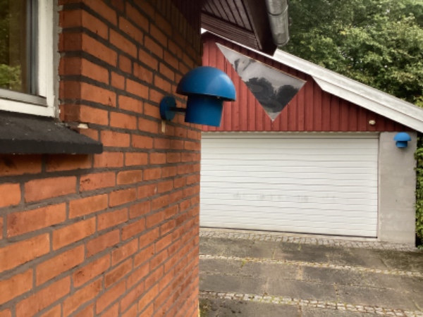 Fastgjort en udendørs lampe, hvor rawplugs er begyndt at arbejde sig ud