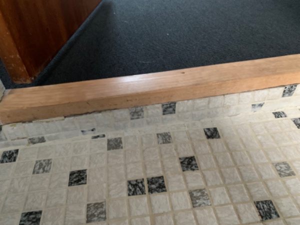 Fuge under dørtrin på badeværelse